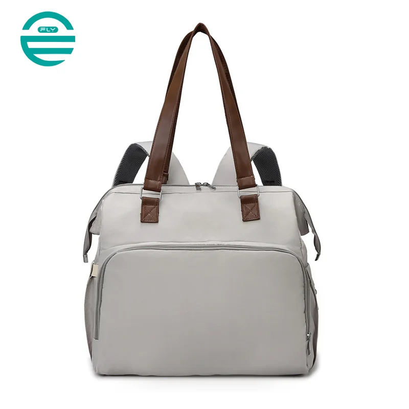 Guangzhou Fuliya Industry Co.,Ltd C-81133 Multi-functional mommy bag, water-resistant, large capacity, foil-insulated bag, wet/dry pocket, and hidden straps - hand or backpack carry with luggage strap for baby outings and travel.